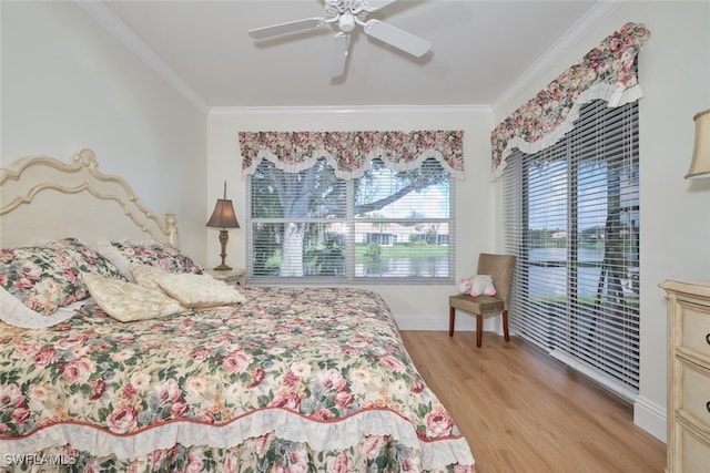 bedroom featuring ceiling fan, light hardwood / wood-style flooring, and ornamental molding