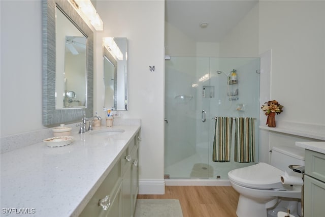 bathroom featuring walk in shower, hardwood / wood-style floors, vanity, and toilet