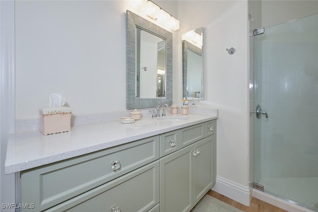 bathroom featuring wood-type flooring, walk in shower, and vanity