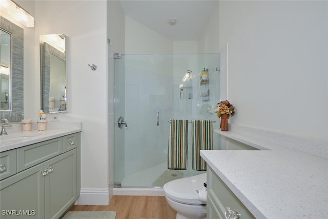 bathroom with walk in shower, toilet, vanity, and hardwood / wood-style floors