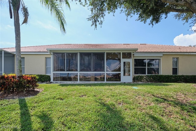 back of property featuring a sunroom and a yard