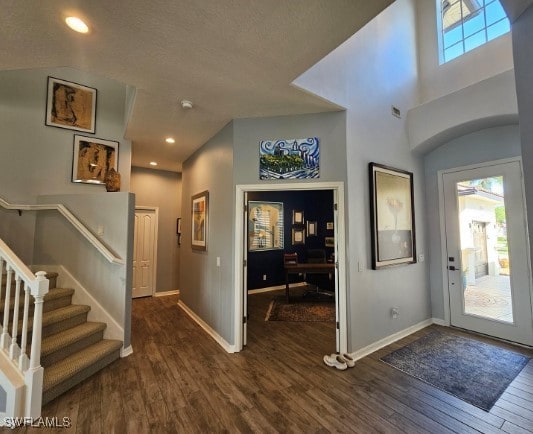 entrance foyer featuring a healthy amount of sunlight, dark hardwood / wood-style floors, and a textured ceiling