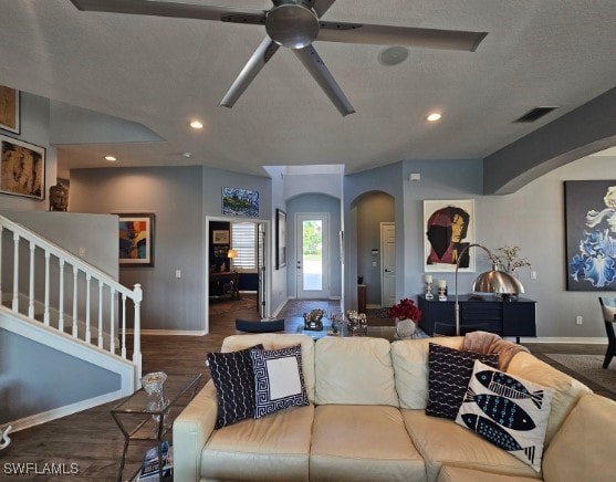 living room featuring ceiling fan, dark wood-type flooring, and vaulted ceiling