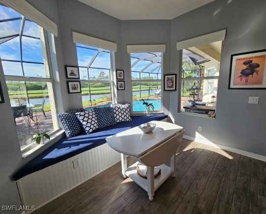 living room featuring plenty of natural light, dark hardwood / wood-style flooring, and a water view