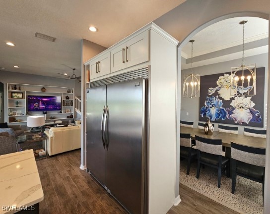 kitchen featuring built in fridge, pendant lighting, white cabinets, and dark hardwood / wood-style flooring