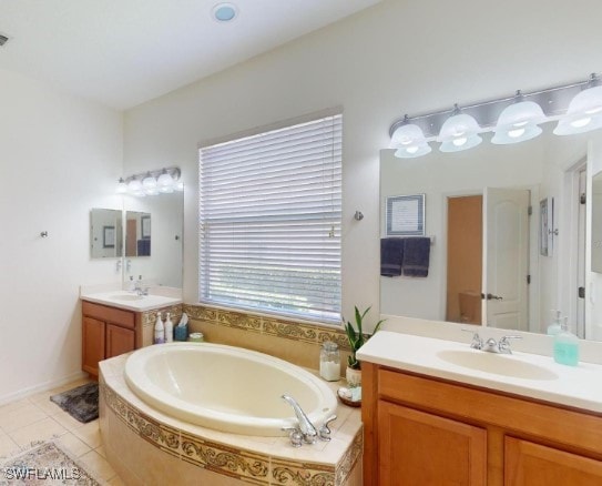 bathroom featuring tiled tub, tile patterned floors, and vanity