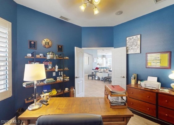 home office featuring a chandelier and light hardwood / wood-style flooring