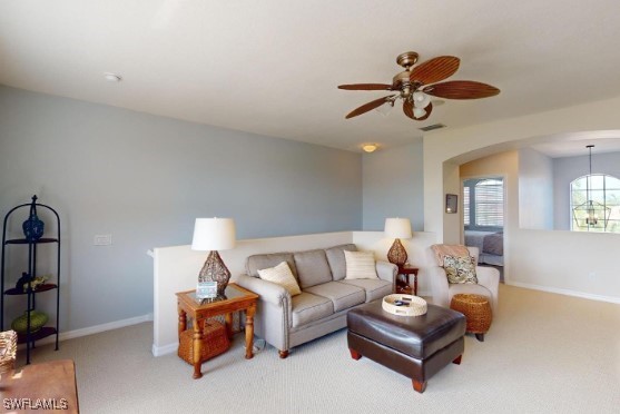 carpeted living room with ceiling fan