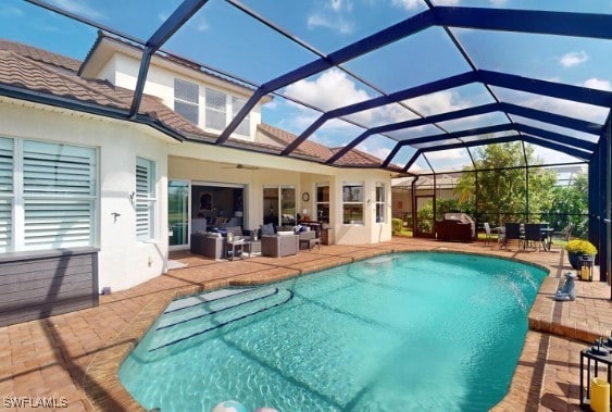 view of swimming pool with glass enclosure and a patio area