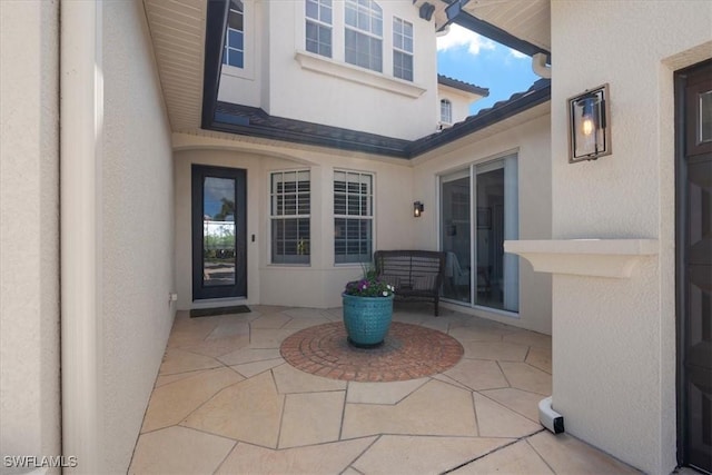 entrance to property with a patio and stucco siding