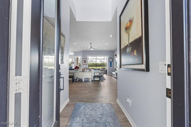 foyer entrance with ceiling fan, baseboards, wood finished floors, and recessed lighting