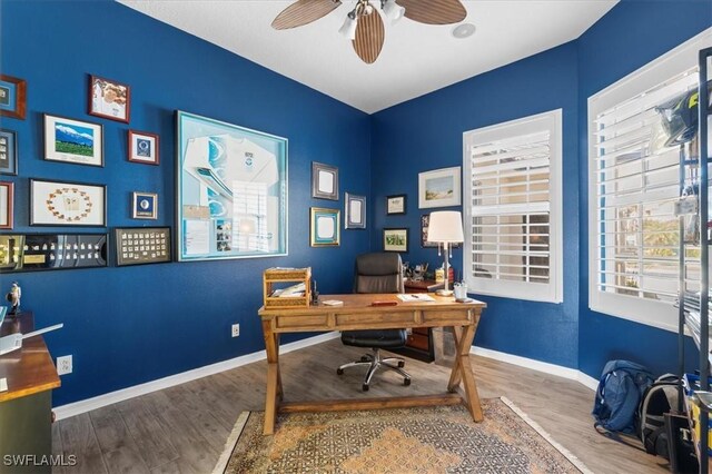 office area featuring wood finished floors, a ceiling fan, and baseboards