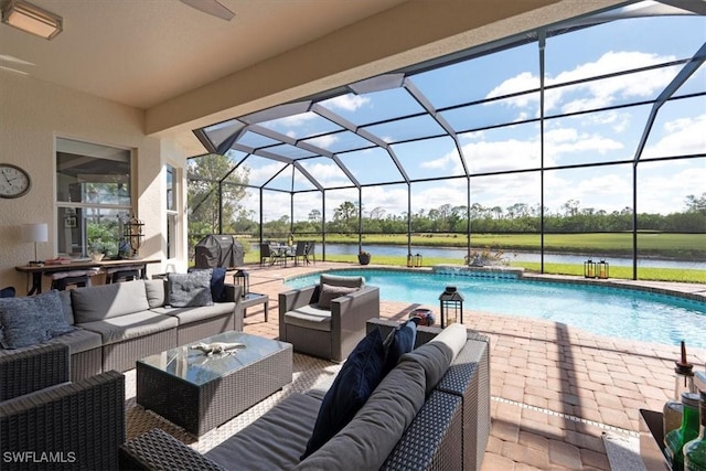 outdoor pool with an outdoor hangout area, glass enclosure, a patio area, and a water view