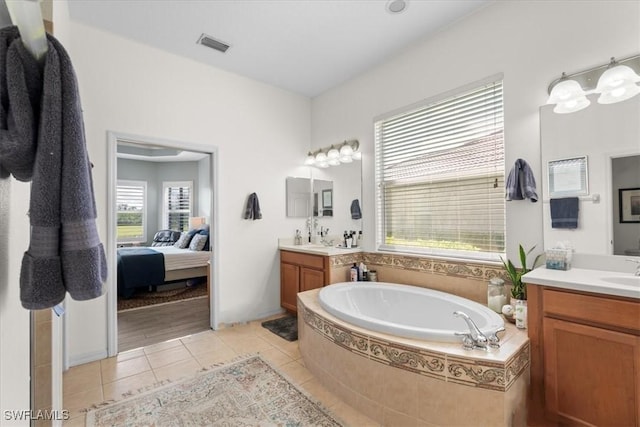 full bathroom with a garden tub, two vanities, visible vents, a sink, and tile patterned flooring