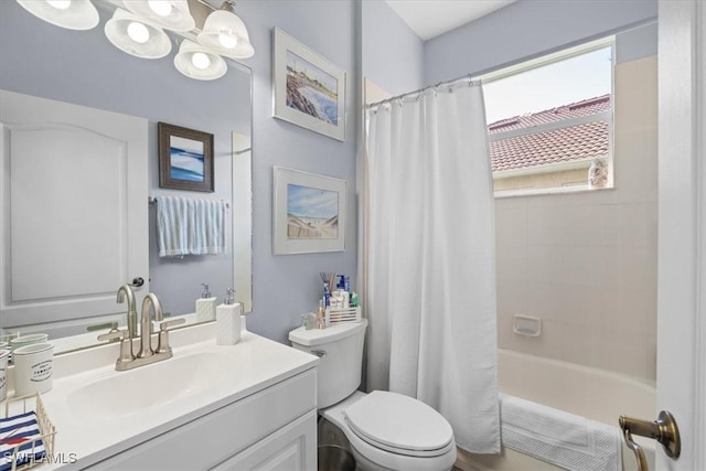 bathroom with toilet, an inviting chandelier, shower / bath combo with shower curtain, and vanity