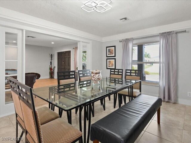 tiled dining area with a textured ceiling