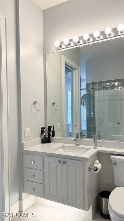 bathroom featuring tile patterned flooring, vanity, toilet, and a shower with shower curtain