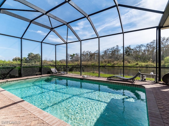 view of swimming pool with a patio and glass enclosure