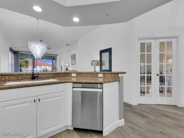 kitchen with dishwasher, sink, white cabinetry, a notable chandelier, and light hardwood / wood-style flooring