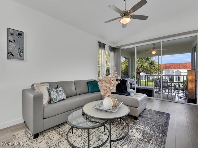 living room with hardwood / wood-style floors, ceiling fan, and vaulted ceiling