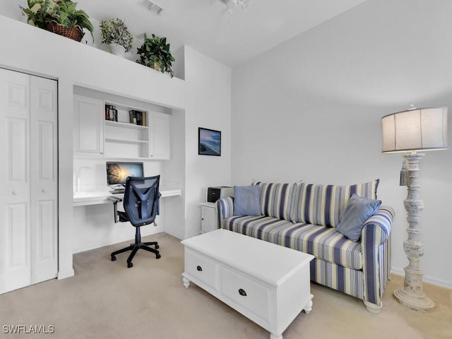 living room with built in desk and light colored carpet