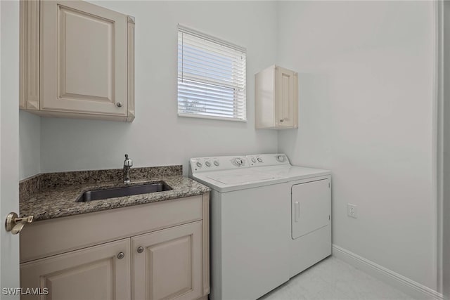 laundry room featuring washer and clothes dryer, sink, and cabinets