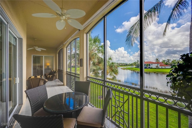 sunroom with a water view and ceiling fan