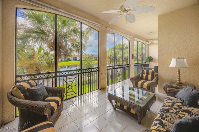 sunroom / solarium with ceiling fan and a water view