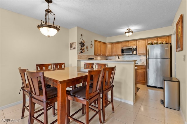 tiled dining area with a textured ceiling and sink