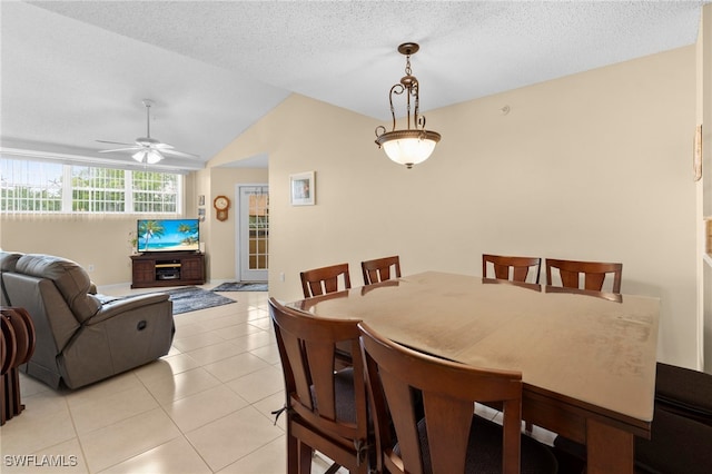 tiled dining room featuring vaulted ceiling, a textured ceiling, and ceiling fan