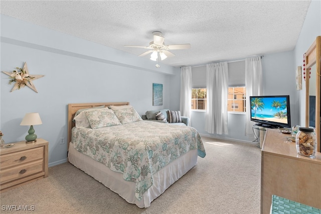 carpeted bedroom featuring ceiling fan and a textured ceiling