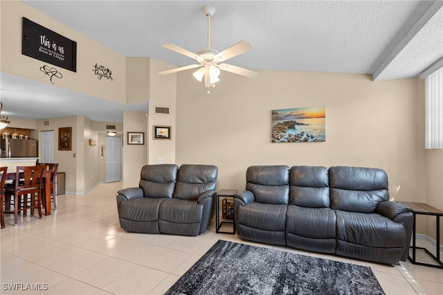 living room featuring ceiling fan, a textured ceiling, lofted ceiling, and light tile patterned floors