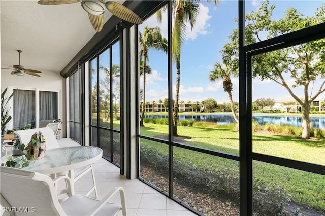 sunroom featuring a water view and ceiling fan