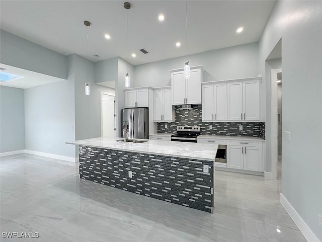 kitchen with a kitchen island with sink, tasteful backsplash, white cabinetry, hanging light fixtures, and appliances with stainless steel finishes