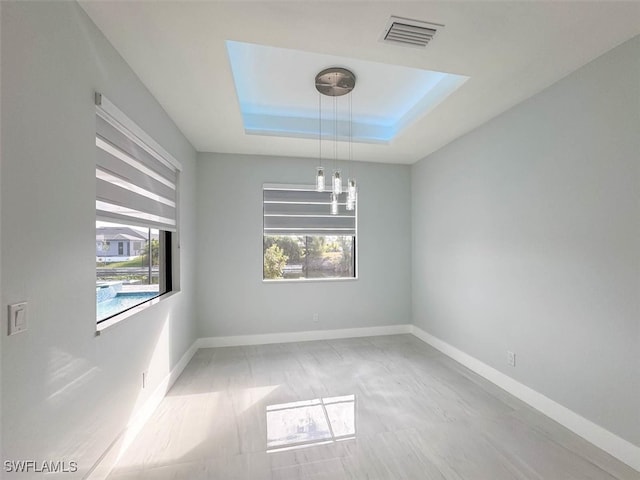 unfurnished room featuring a raised ceiling