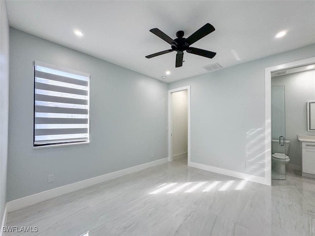 unfurnished bedroom with ceiling fan, ensuite bath, and multiple windows