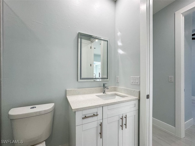 bathroom featuring vanity, toilet, and hardwood / wood-style flooring