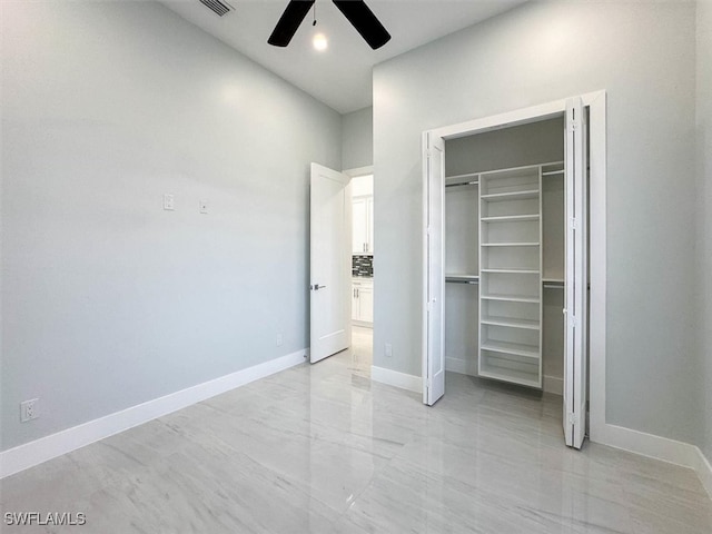 unfurnished bedroom with ceiling fan and a closet