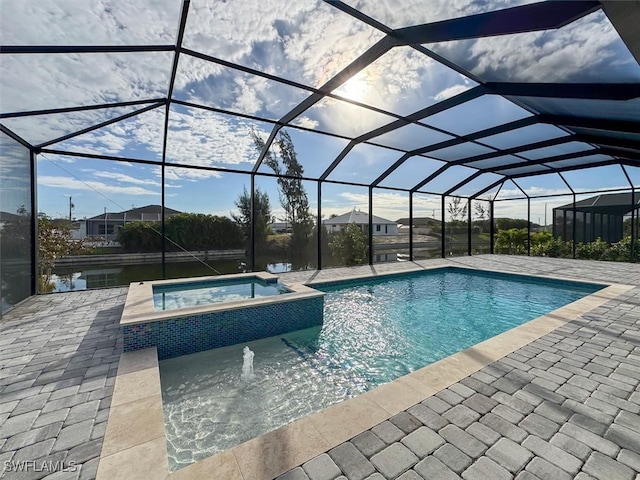 view of swimming pool featuring glass enclosure, an in ground hot tub, and a patio