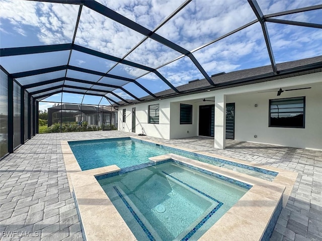 view of pool featuring ceiling fan, glass enclosure, an in ground hot tub, and a patio area