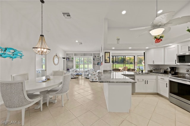 kitchen with sink, decorative light fixtures, white cabinetry, appliances with stainless steel finishes, and dark stone counters