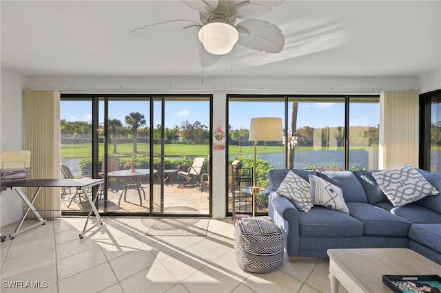 sunroom with a water view and ceiling fan