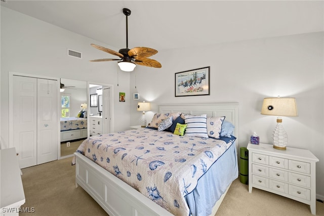 bedroom with ceiling fan, light colored carpet, a closet, and lofted ceiling