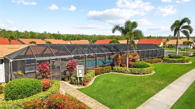 exterior space with glass enclosure and a yard