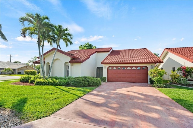 mediterranean / spanish house with a front lawn and a garage