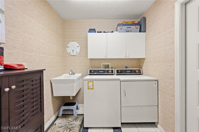 washroom with light tile patterned flooring, independent washer and dryer, cabinets, and sink