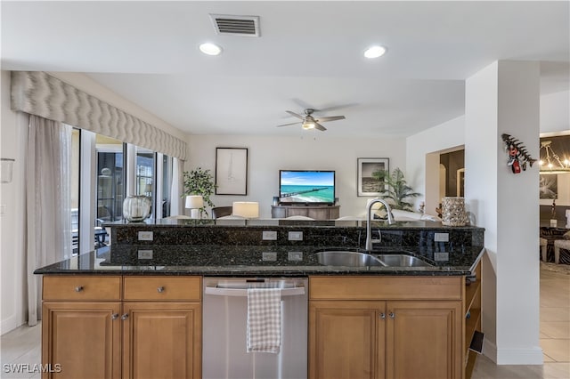 kitchen with ceiling fan, sink, light tile patterned flooring, dark stone counters, and dishwasher