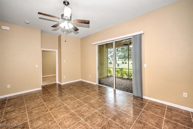 empty room featuring dark tile patterned floors and ceiling fan