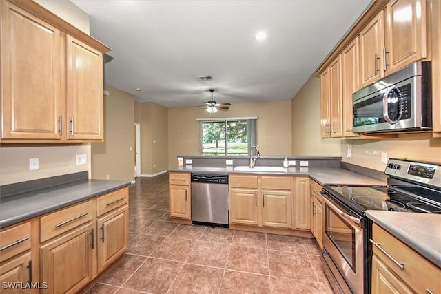 kitchen featuring kitchen peninsula, stainless steel appliances, tile patterned flooring, ceiling fan, and sink