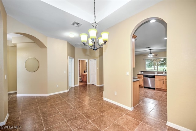 tiled spare room with ceiling fan with notable chandelier and sink